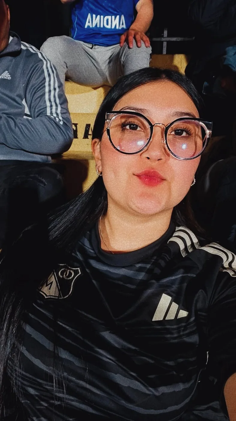 Hincha con gafas y la camiseta negra de Millonarios en la tribuna